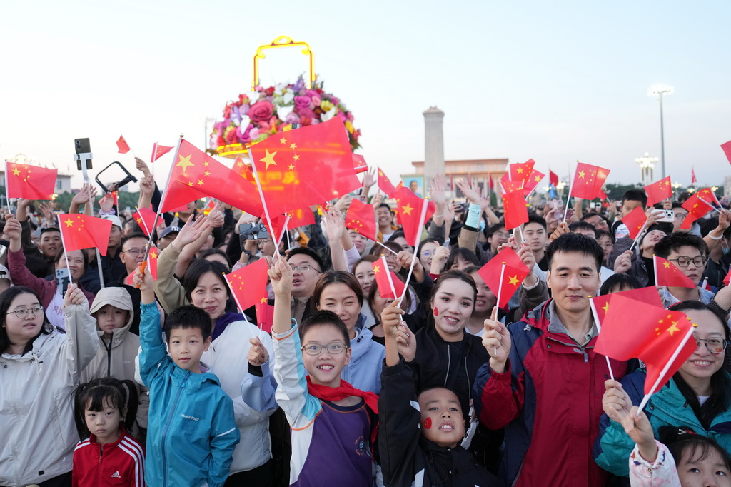 10月1日清晨,隆重的升国旗仪式在北京天安门广场举行,庆祝中华人民共和国成立76周年。这是观众在升旗仪式后欢呼。 新华社记者 鞠焕宗 摄
