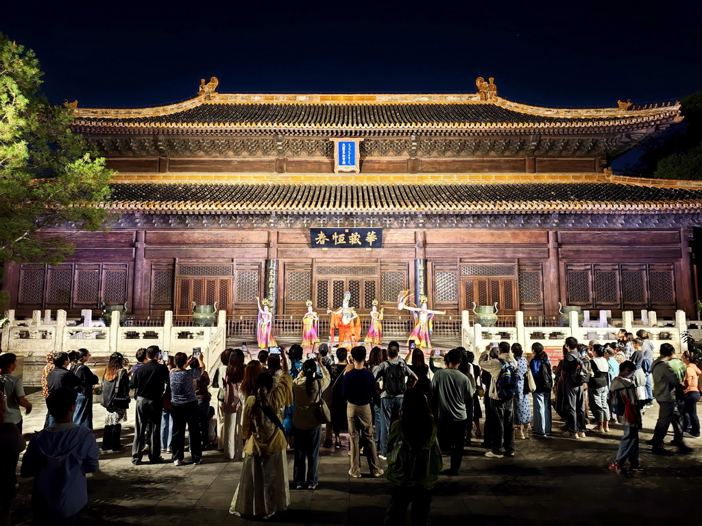 10月2日,游客在北京北海公园观看演出,在夜色中的古典园林里感受传统文化魅力。新华社记者 邢广利 摄