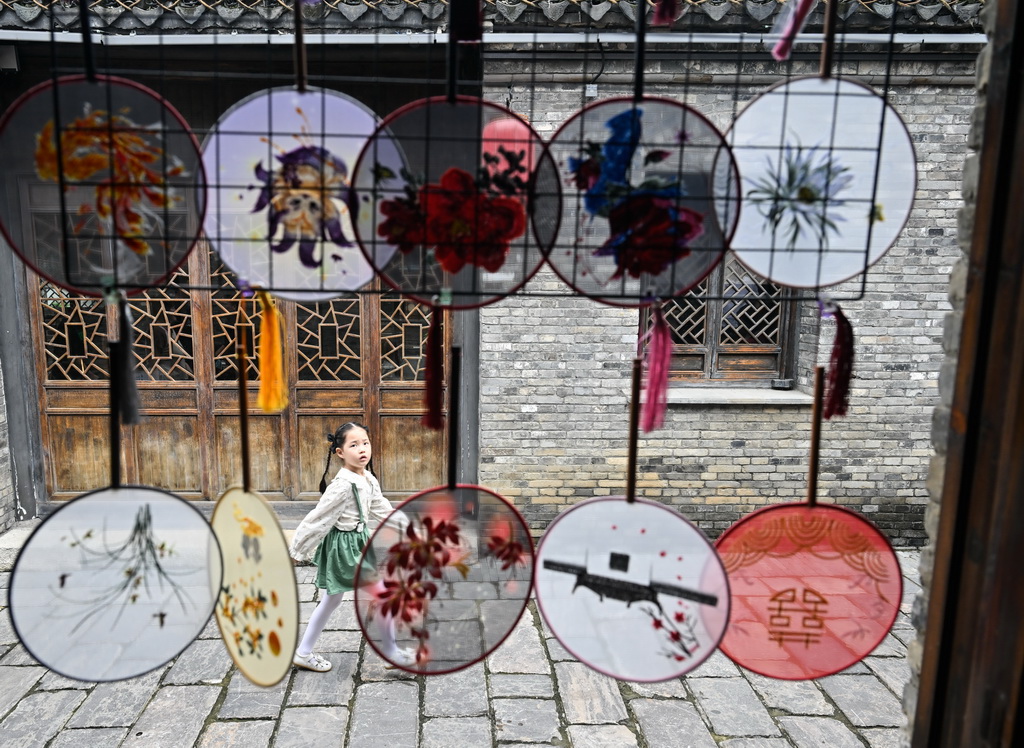 10月1日,小朋友走在盱眙县第一山历史文化街区。国庆、中秋双节期间,江苏省盱眙县推出部分景区免门票、发放消费券等惠民措施,举办丰富多彩的文旅活动。新华社记者 季春鹏 摄